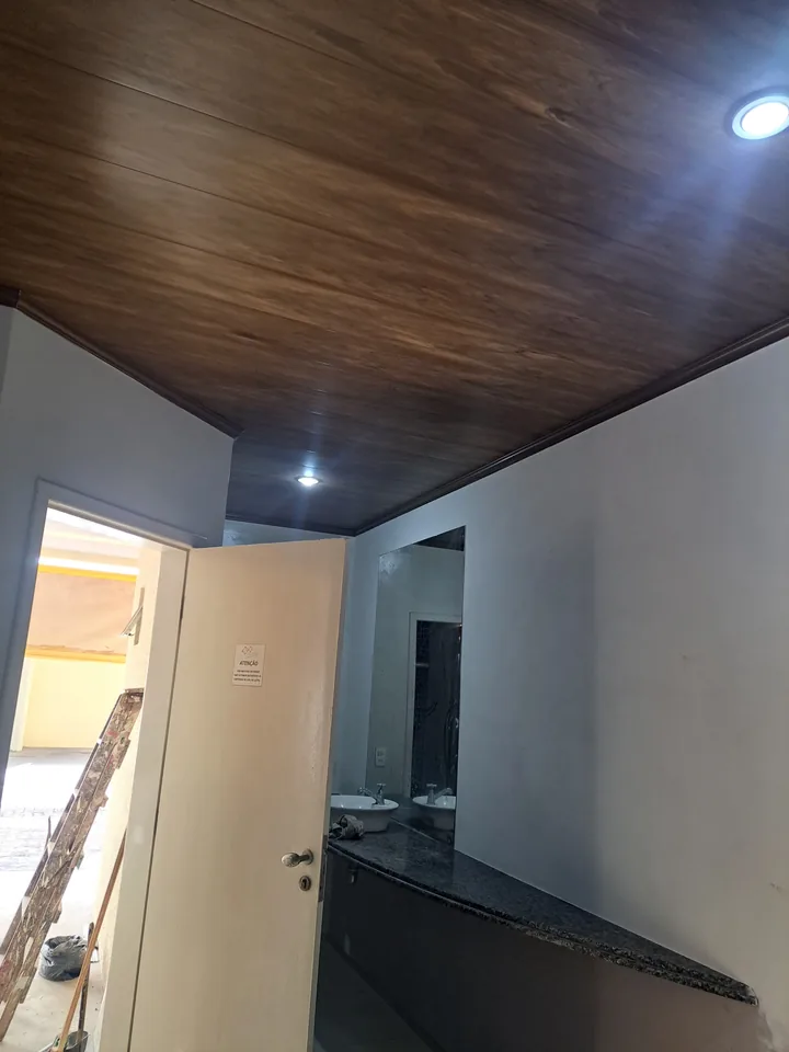 Ambiente interno com forro de acabamento amadeirado e iluminação embutida